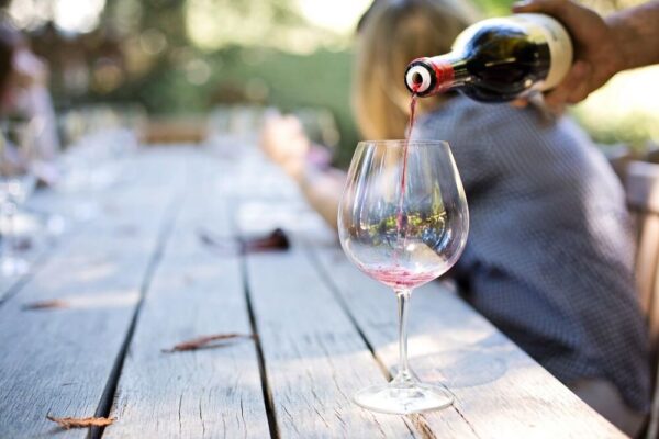 a glass of wine beoing poured from the bottle