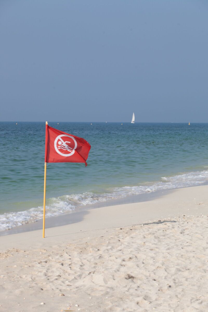 Panama City Beach with warning flag stuck in sand