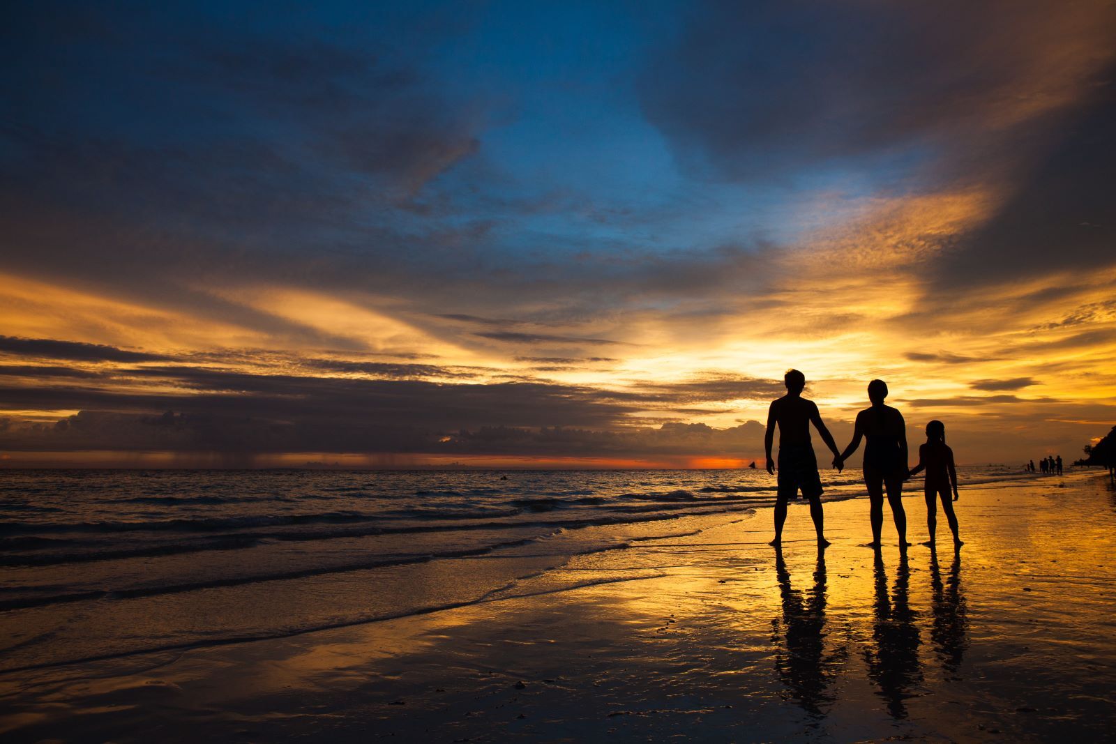 Family walking on Panama City Beach after sunset