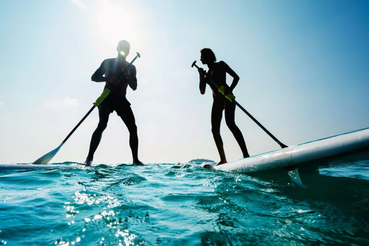 A couple paddleboarding on Panama City Beach