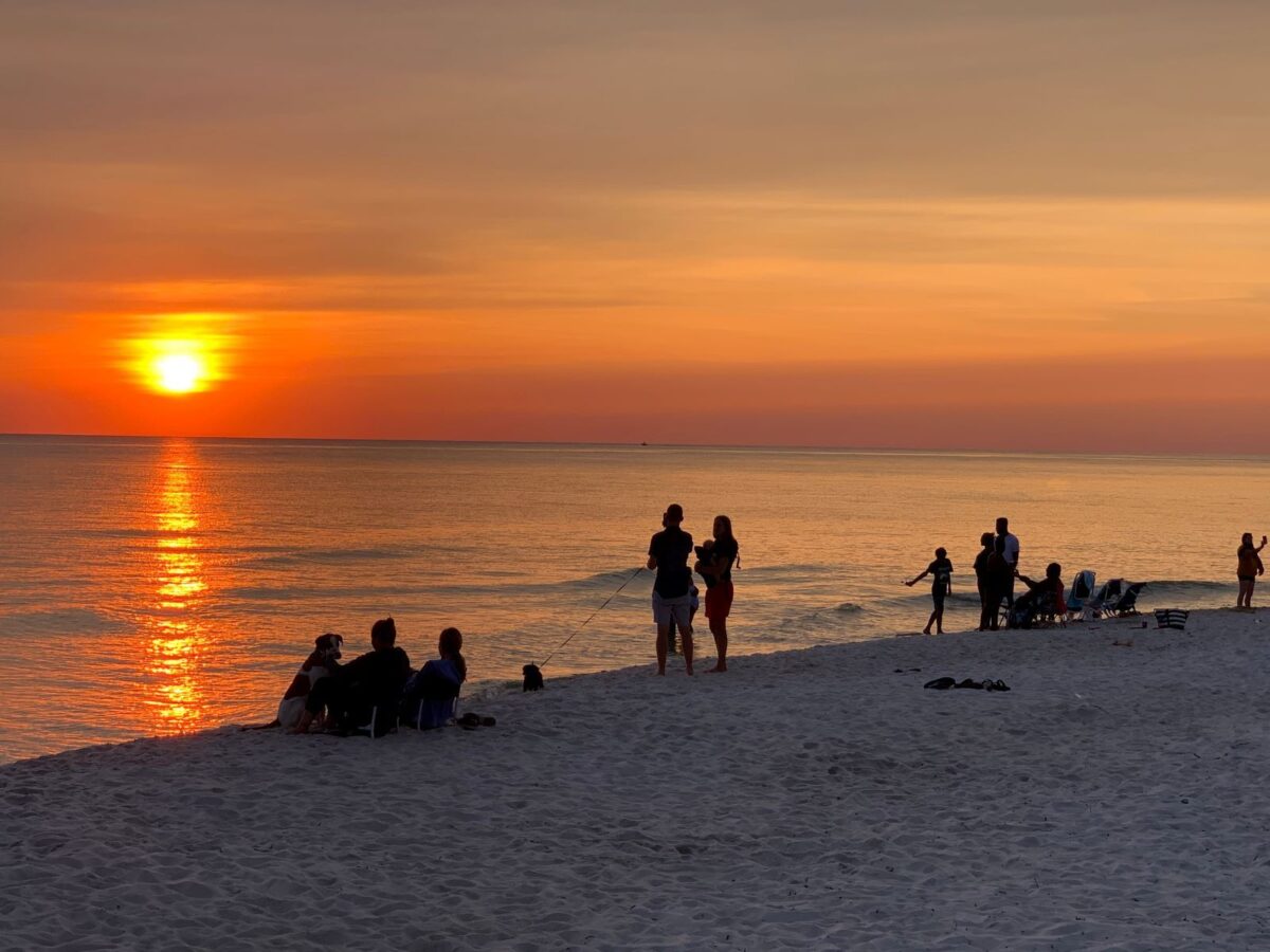 Families on beach watch sunset