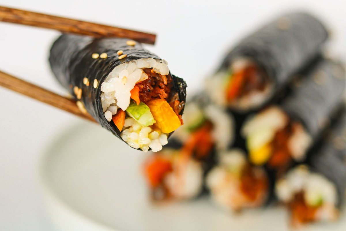 sushi roll held by chop sticks